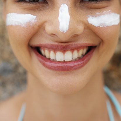 Front view portrait of a woman with sun cream on her face